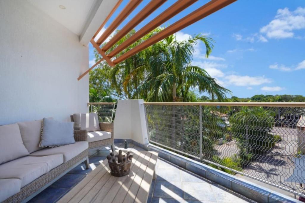 ein Wohnzimmer mit einem Sofa auf dem Balkon in der Unterkunft 2 Bedroom Top Floor Parap Delight New to Market in Parap