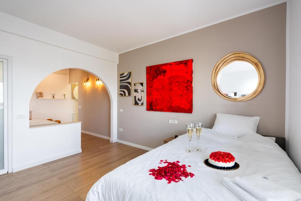 a bedroom with a white bed with red flowers on it at Sunset - Luxury Studio on Calea Victoriei in Bucharest