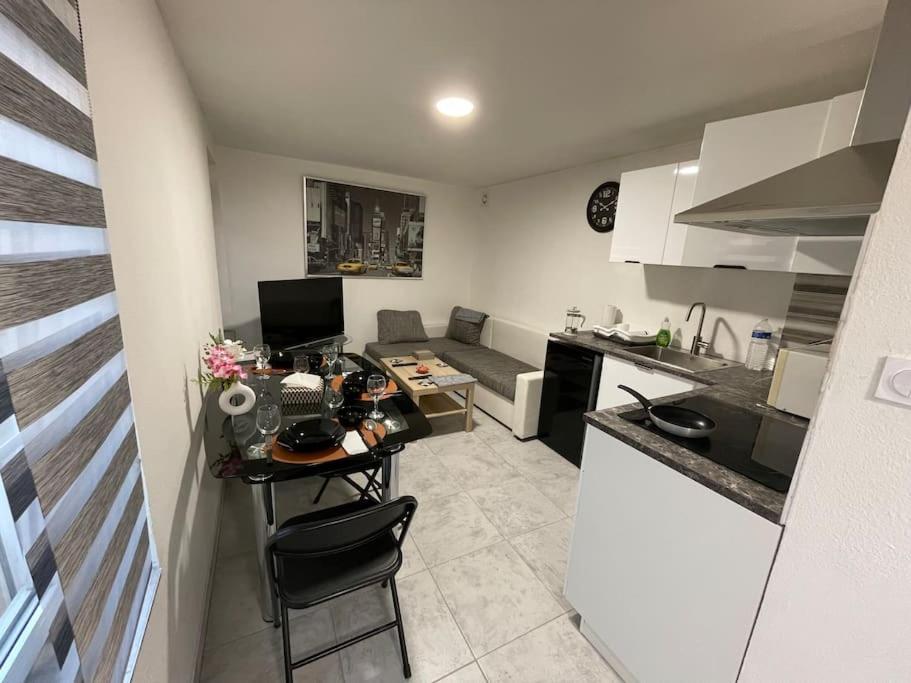 - une petite cuisine avec une table et un comptoir dans l'établissement Agréable et spacieux appartement, à Schiltigheim