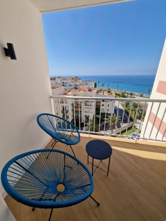 Un balcón con dos sillas y vista al mar. en Estudio 8, en Salobreña
