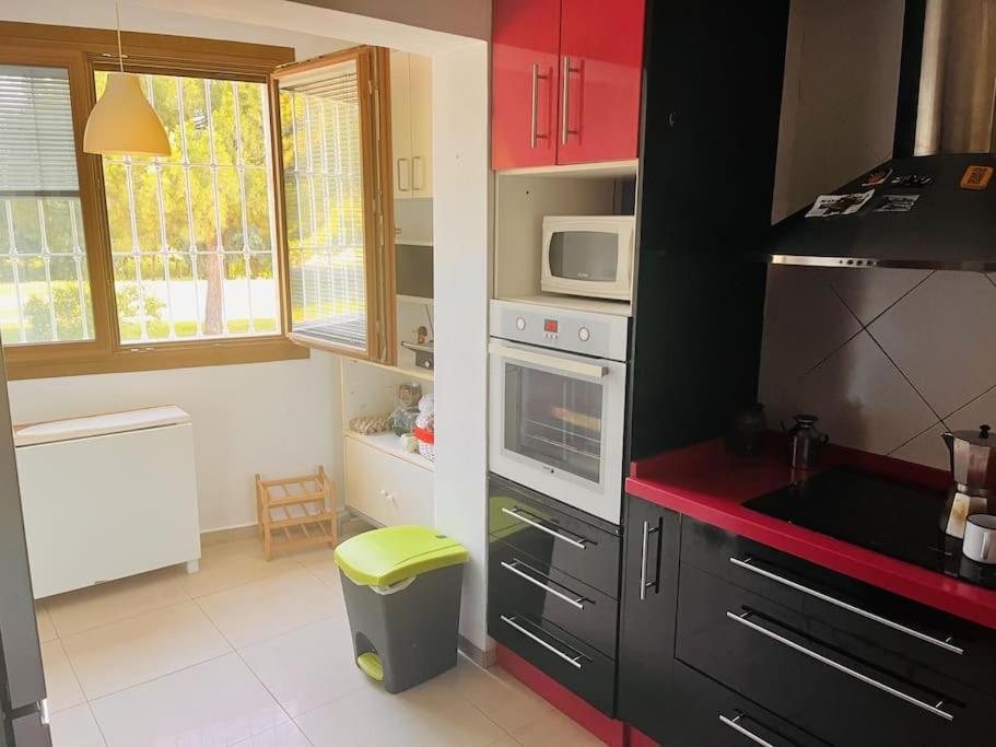 a small kitchen with red cabinets and a microwave at Apartamento de la Cruz in Merida