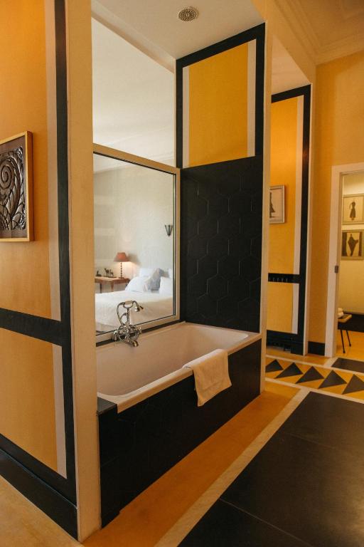Cette chambre comprend un lit et une salle de bains pourvue d'une baignoire. dans l'établissement Room in Guest room - Guest room in an exceptional villa, au Pradet