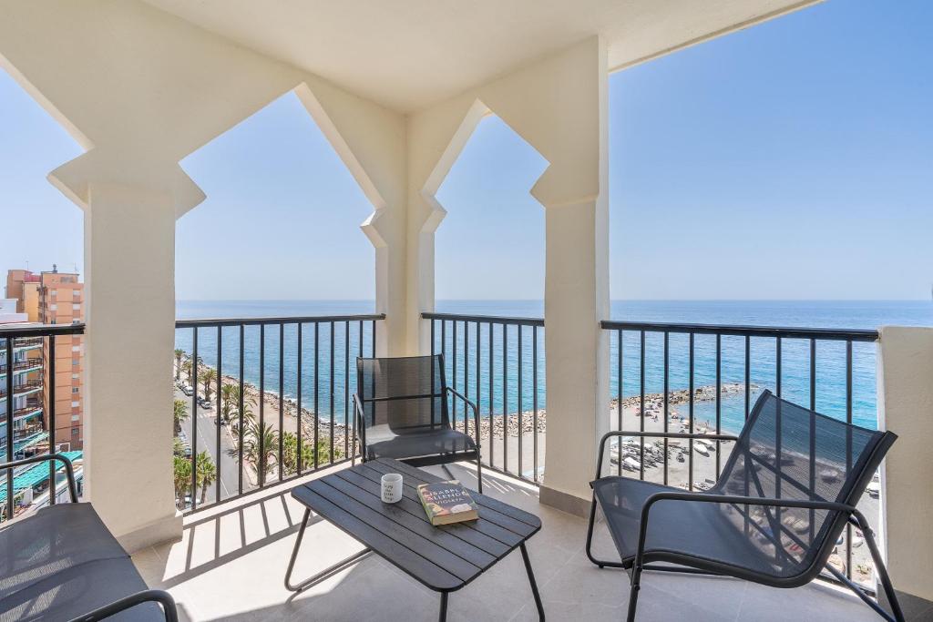 een balkon met een tafel en stoelen en de oceaan bij Cielo y Mar in Almuñécar