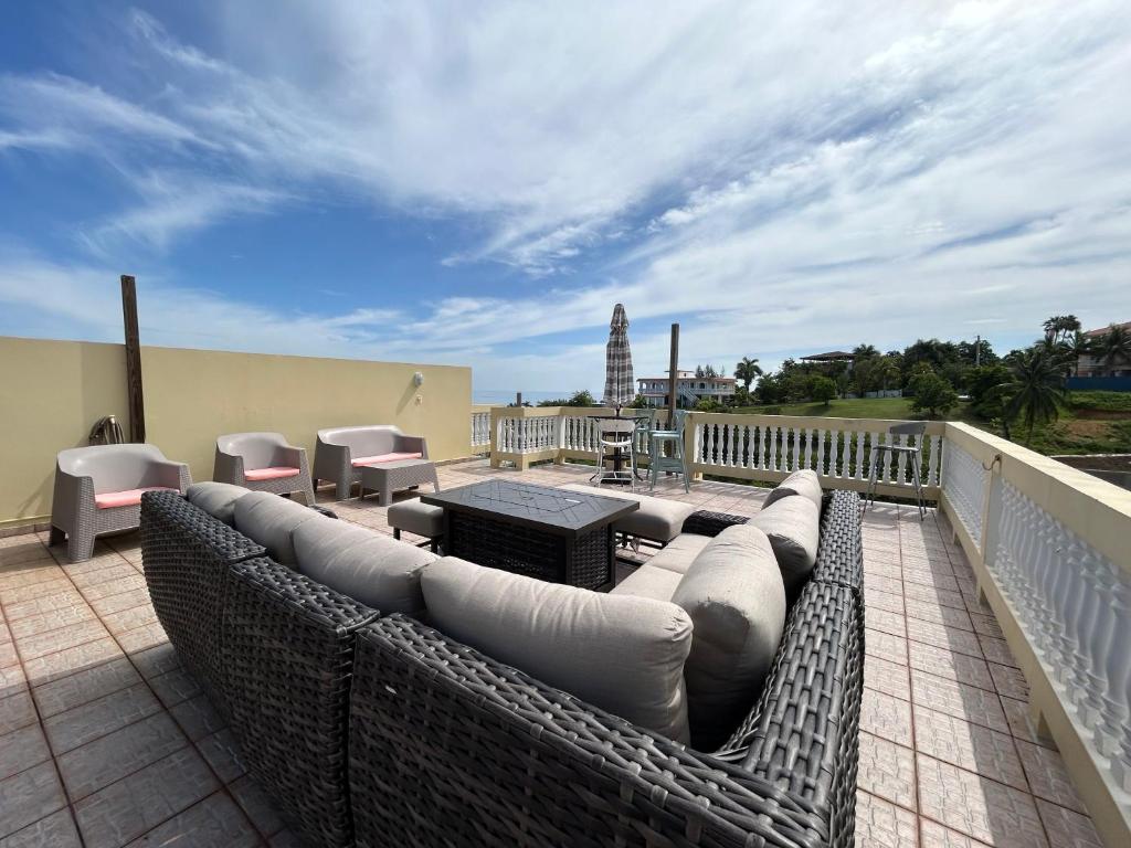un patio avec des meubles en osier sur un balcon dans l'établissement Puntas Rincon Villa 301 with private rooftop terrace, à Rincon