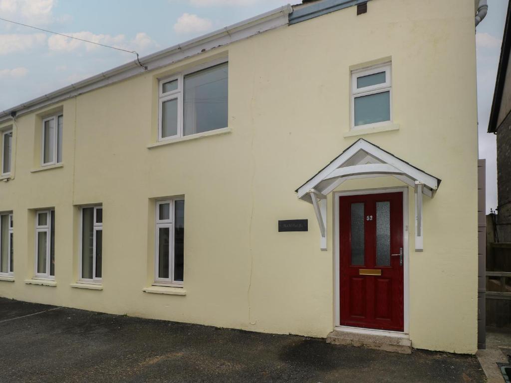 a white house with a red door at The Old Post Office in Haverfordwest