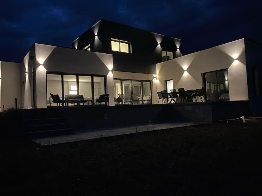 une maison éclairée la nuit avec des lumières dans l'établissement Maison Contemporaine, à Villez-sous-Bailleul