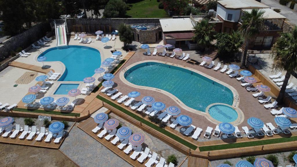 an overhead view of a swimming pool with chairs and umbrellas at Bodrum Liman Resort in Bodrum City