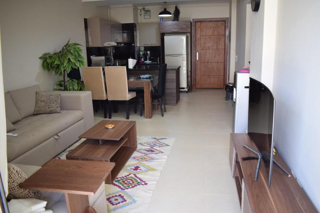 una sala de estar con un sofá y una mesa en Whispering Waters Two Bedroom with a Garden Azha, en Ain Sokhna