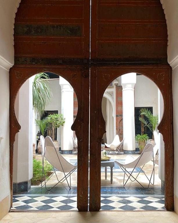 an archway with chairs and a table in a courtyard at Dar El Qadi in Marrakech