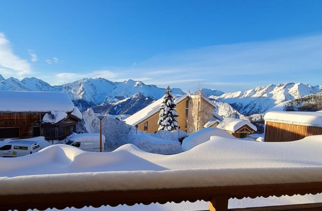 une ville enneigée avec des montagnes en arrière-plan dans l'établissement Studio Vieil Alpe avec vue et garage privé, à Huez