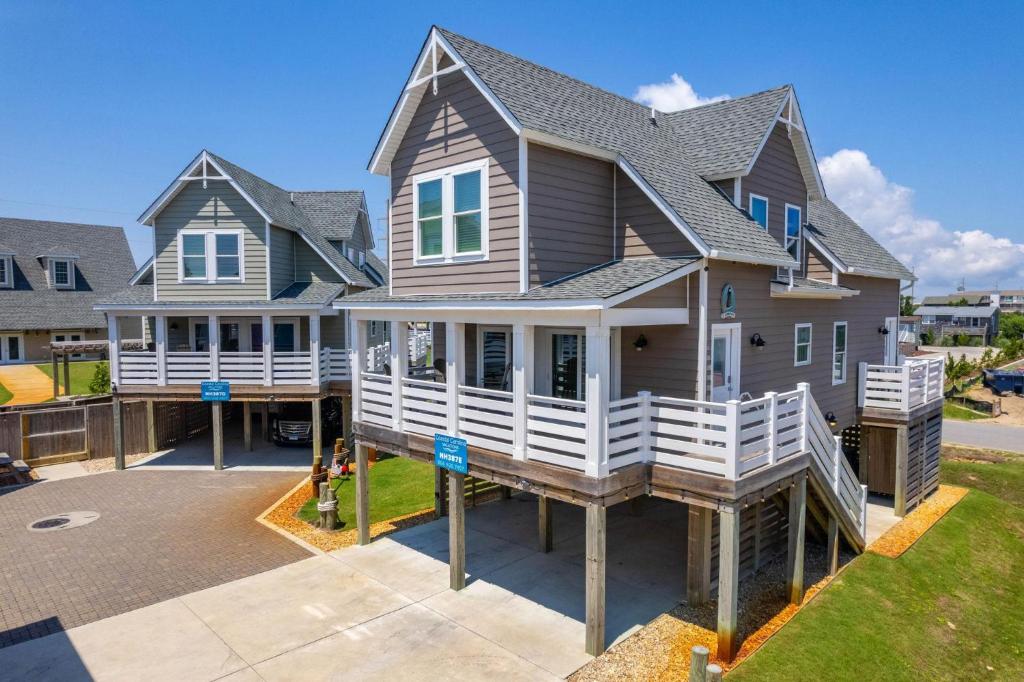 une grande maison avec un porche et une allée dans l'établissement NH387E Currituck Cottage, à Nags Head