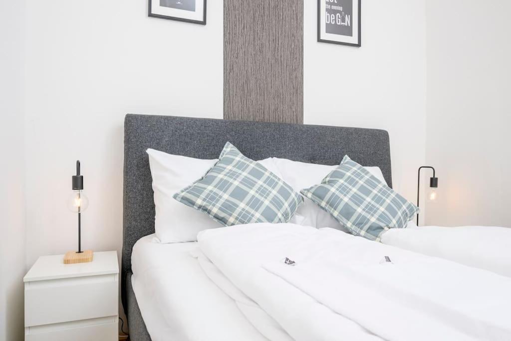 Una cama blanca con almohadas azules y blancas. en Anna and Friends First floor, en Graz