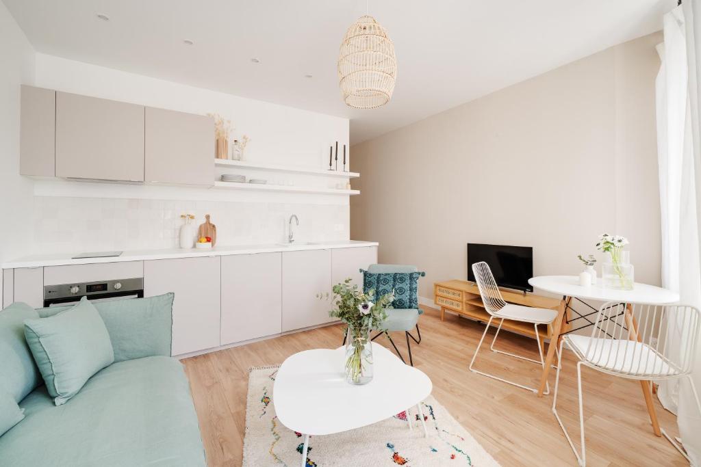 Una sala de estar con un sofá azul y una mesa. en Le Coquet des Trois-Maisons avec parking privatif, en Nancy