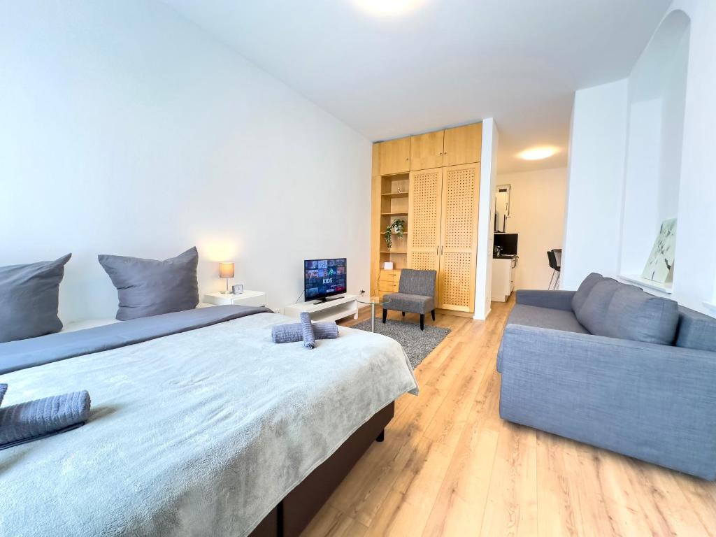 a bedroom with a large bed and a couch at Moderne Wohnung im Zentrum der Altstadt - Altbau Flair, WLAN in Ingolstadt