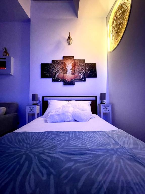 une chambre avec un grand lit aux murs bleus dans l'établissement GI-AZ Love room, à Bondy