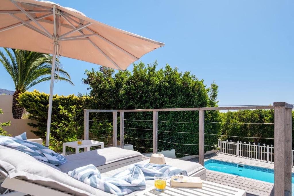 a patio with an umbrella and a swimming pool at Sea Escape in Cape Town
