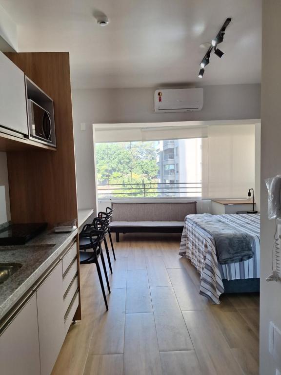 a kitchen and a bedroom with a bed and a window at Studio Butantã Novíssimo in São Paulo