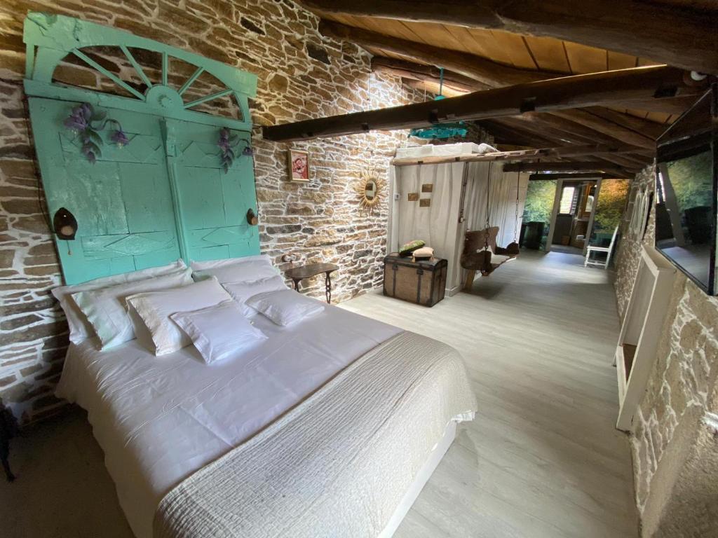 a bedroom with a bed and a brick wall at O Forno de Catuxa Cottage & Roman Wall in Lugo