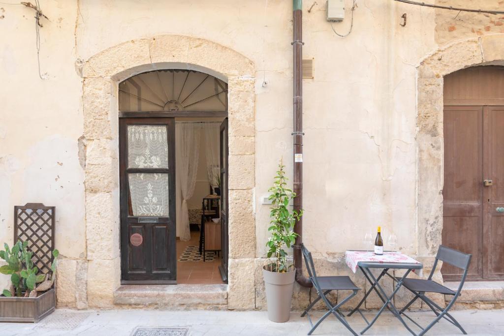 a table and chairs in front of a building at Casa Ariadne by Ortigia Apartments in Syracuse