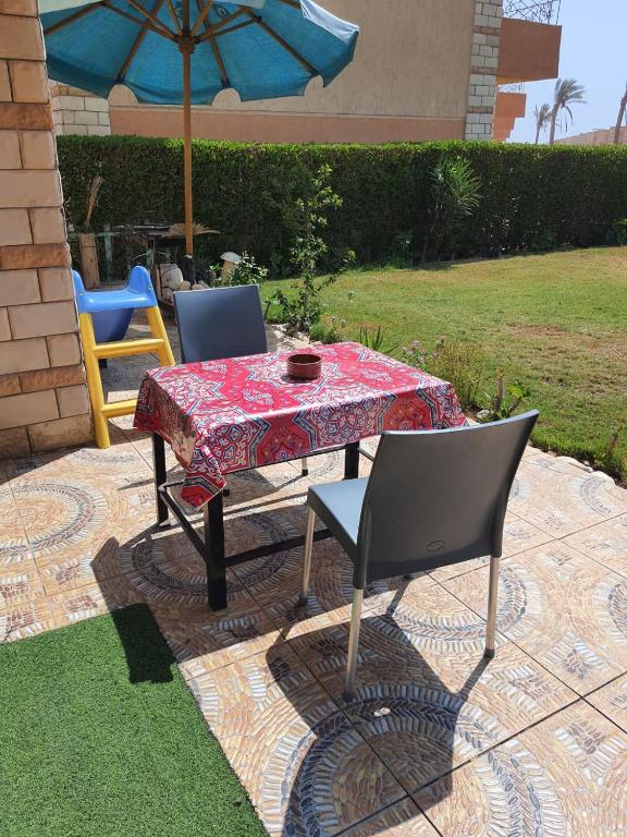 a table with two chairs and an umbrella at New venisia Resort in Ain Sokhna