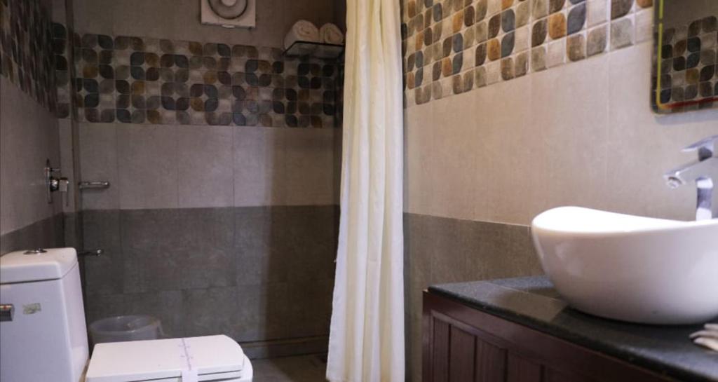a bathroom with a sink and a toilet and a shower at Wayanad Kuruva Isles Jungle Resort in Chekadi