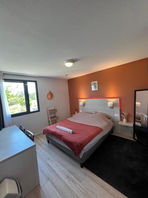 a bedroom with a large bed with a red blanket at Studio Appart'hôtel gare TGV avec place privée in Avignon