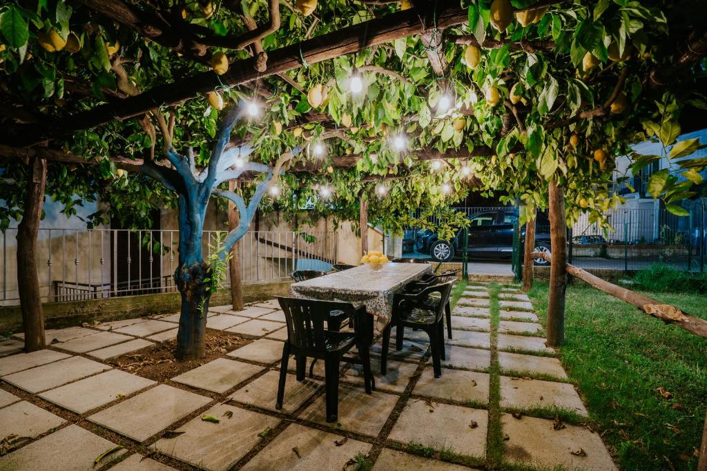 a table and chairs under a pergola with lights at Il Giardino dei limoni in Polvica