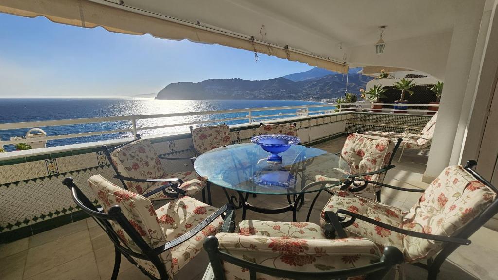 a balcony with a table and chairs and the ocean at Apartamento Las Terrazas in La Herradura