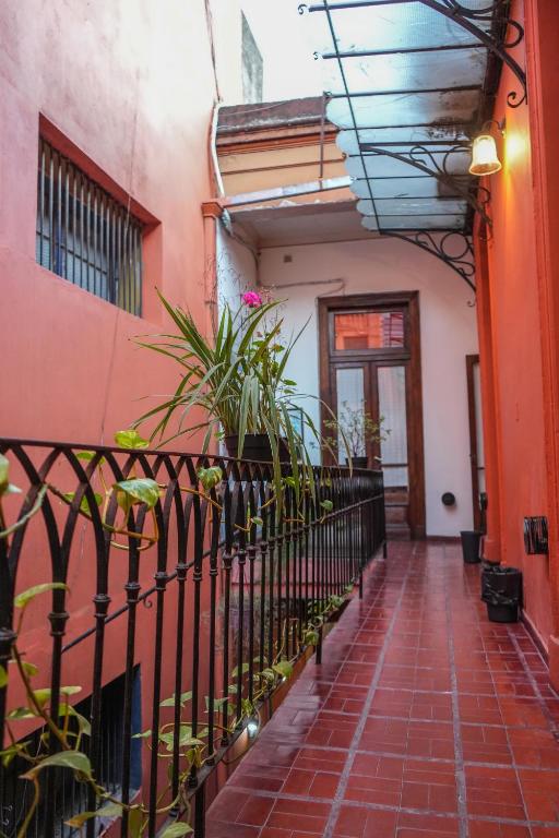 a hallway of a building with a fence and plants at ViaVia Buenos Aires GuestHouse in Buenos Aires