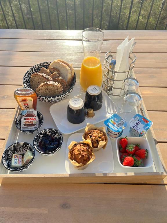 a tray with breakfast foods and a glass of orange juice at LOVE ROOM Tente Lodge spa MFG chez C&C, exclusivement réservée aux ADULTES in Cantaron