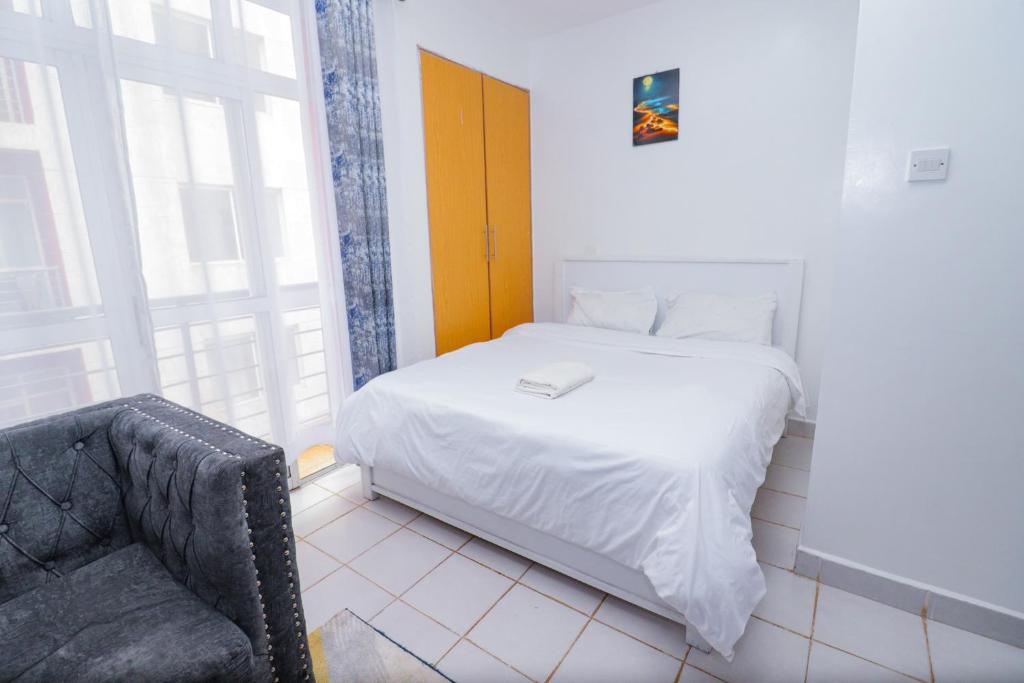 una piccola camera con letto e sedia di Serene studio along Ngong road-Nairobi a Nairobi
