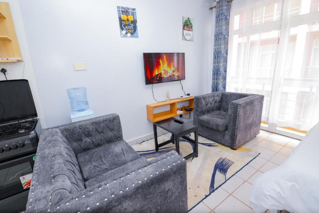 un soggiorno con 2 divani e una TV di Serene studio along Ngong road-Nairobi a Nairobi