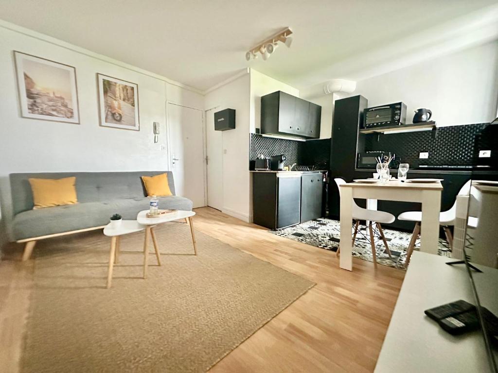 un salon avec un canapé et une table dans l'établissement Les Arènes, zen et moderne, à Limoges