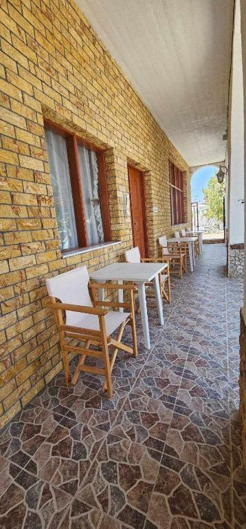 un patio con mesas y sillas junto a un edificio de ladrillo en Hotel Palladion, en Karterados