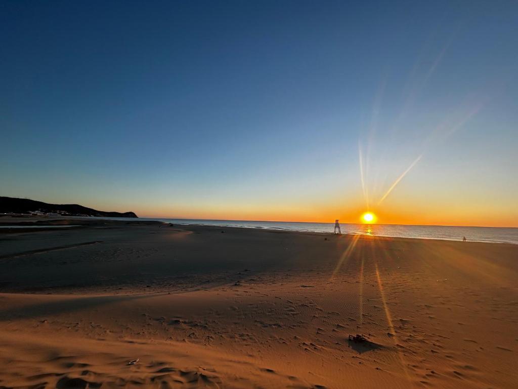 a person standing on the beach at sunset at Serene & Joyful Retreat - Breathtaking view in Cabo Negro
