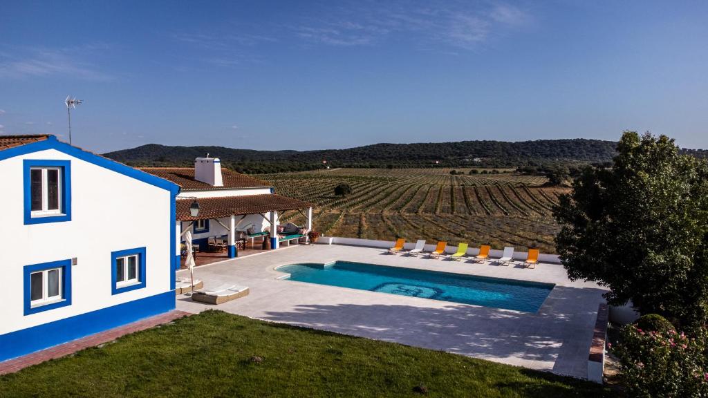a house with a swimming pool next to a field at Monte do Melo in Montemor-o-Novo