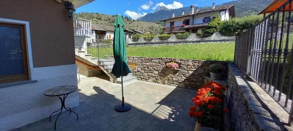 patio con ombrellone e tavolo con fiori di Maison Cocò ad Aosta