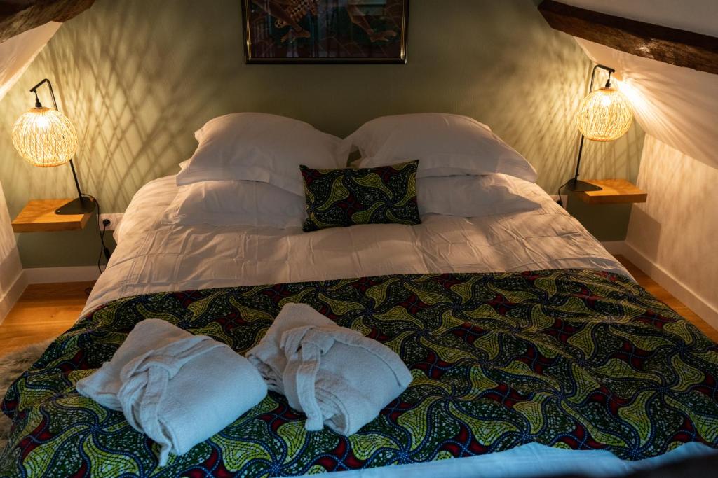 a bed with two pillows on it in a bedroom at la Bastide du Laizon & Spa in Maizières