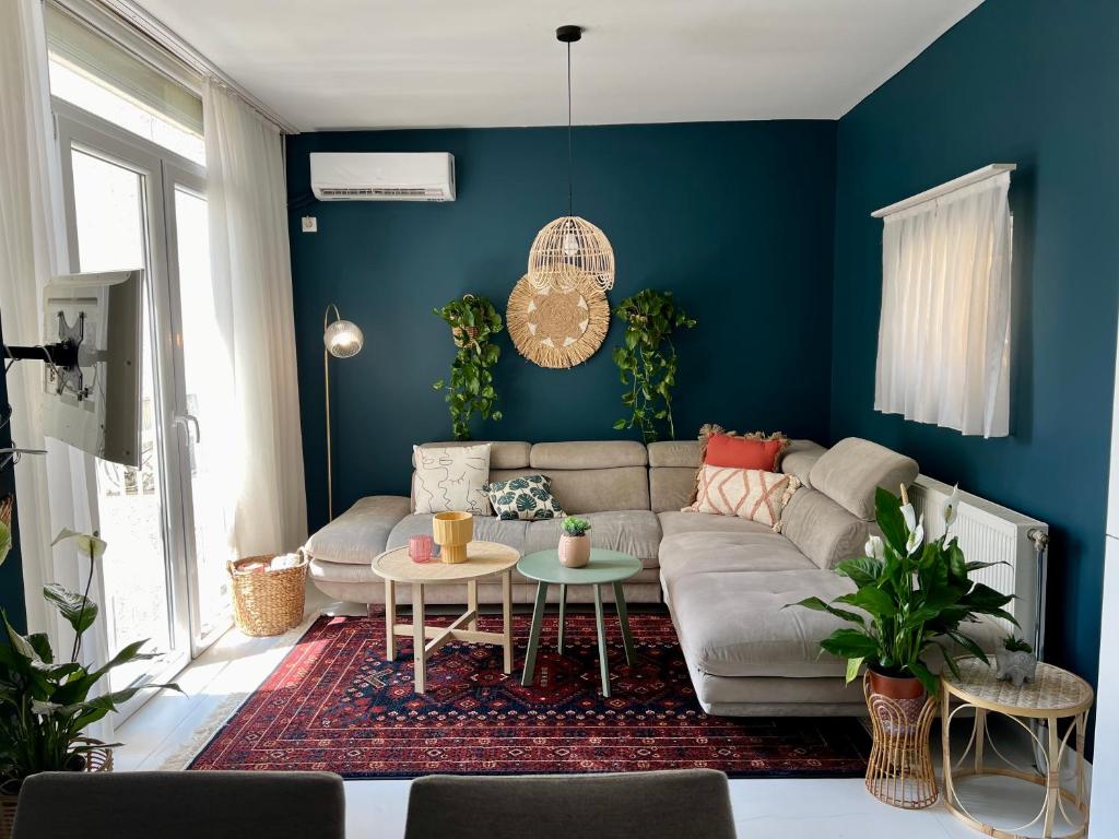 a living room with a couch and a blue wall at Blue & Bright Central in Pristina