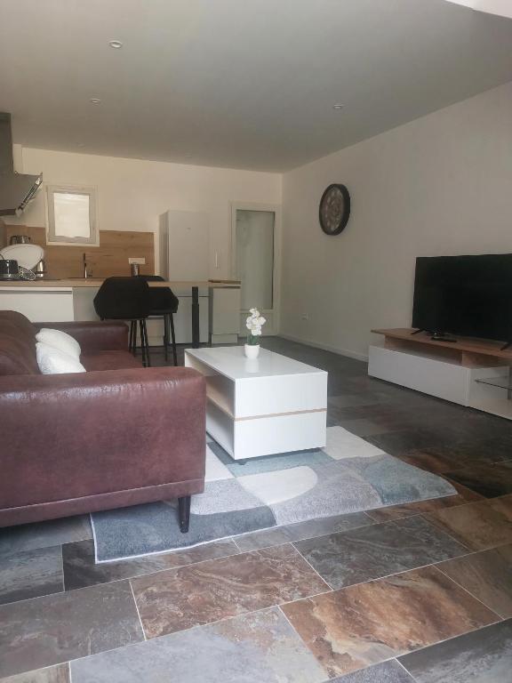 un salon avec un canapé et une télévision à écran plat dans l'établissement La Parenthèse, à Moussan