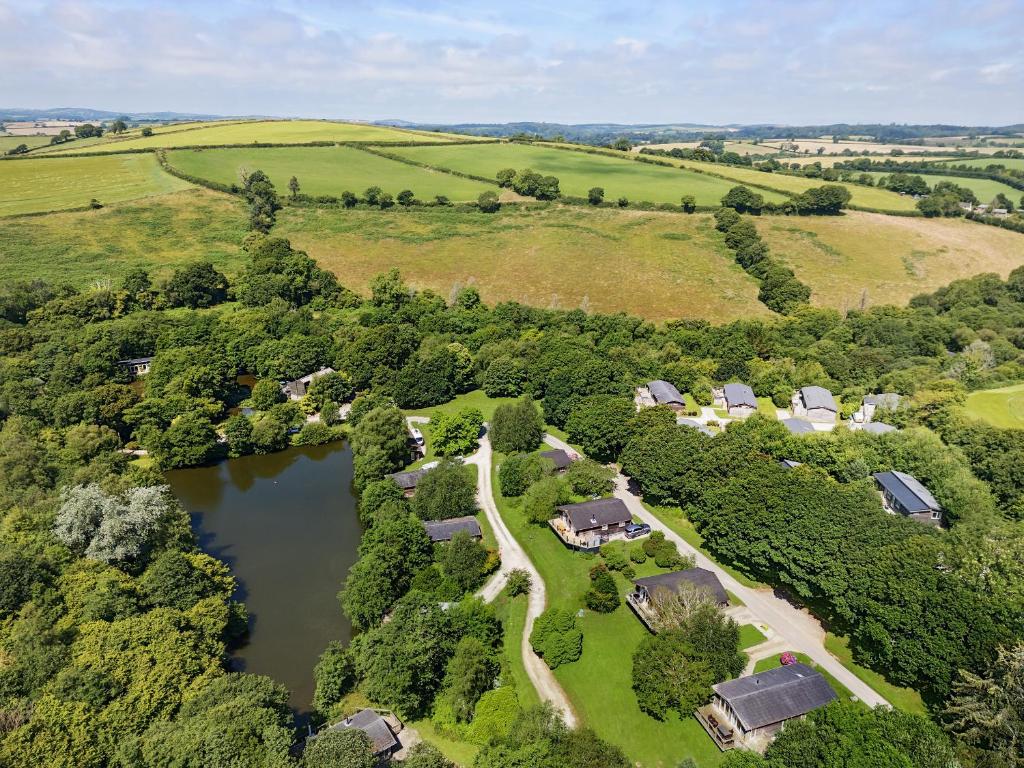 an aerial view of a farm with a lake at 9 Stonerush Valley in Looe