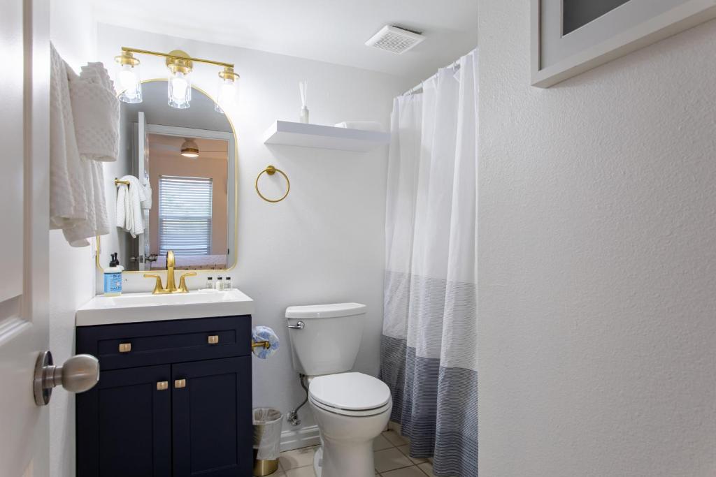 ein Badezimmer mit Toilette, Waschbecken und Spiegel in der Unterkunft Pelican&#39;s Landing in Destin