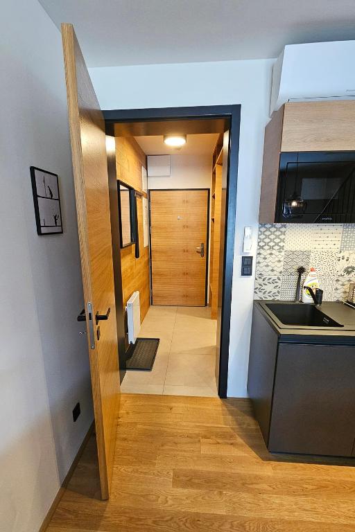 Kuchyň nebo kuchyňský kout v ubytování ENJOYHARRACHOV - Atraktivní klidný klimatizovaný apartmán 20 v centru Harrachova s parkováním, Wifi-WLAN, SAT, herní konzolí, Ipad, Netflix zdarma, možností dobíjení auta, výhledem do zahrady a na romantický kostelík