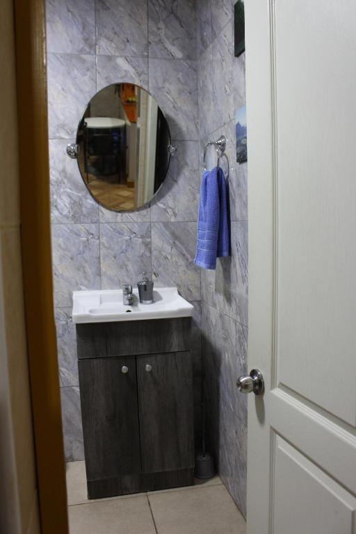 un bagno con lavandino e specchio di Hostal Familiar S&G a Santiago