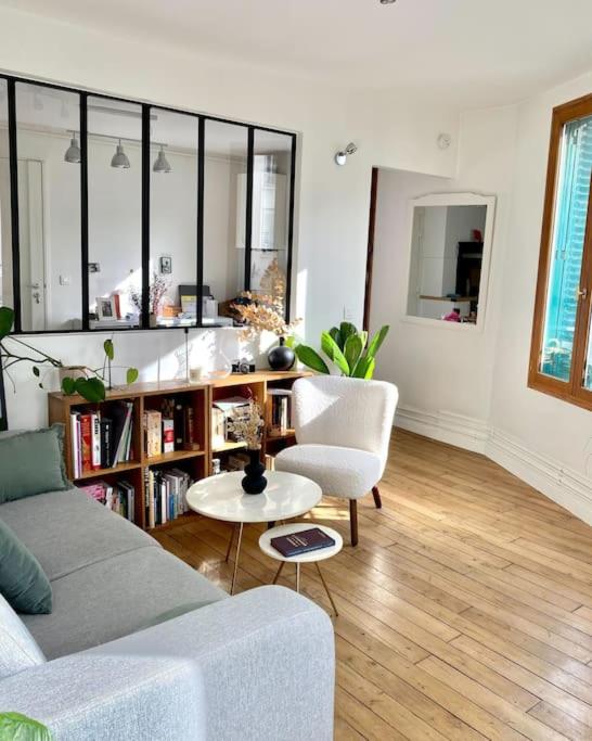 un salon avec un canapé et une table dans l'établissement Nice Flat next to Olympic village & Stade de France, à Saint-Ouen