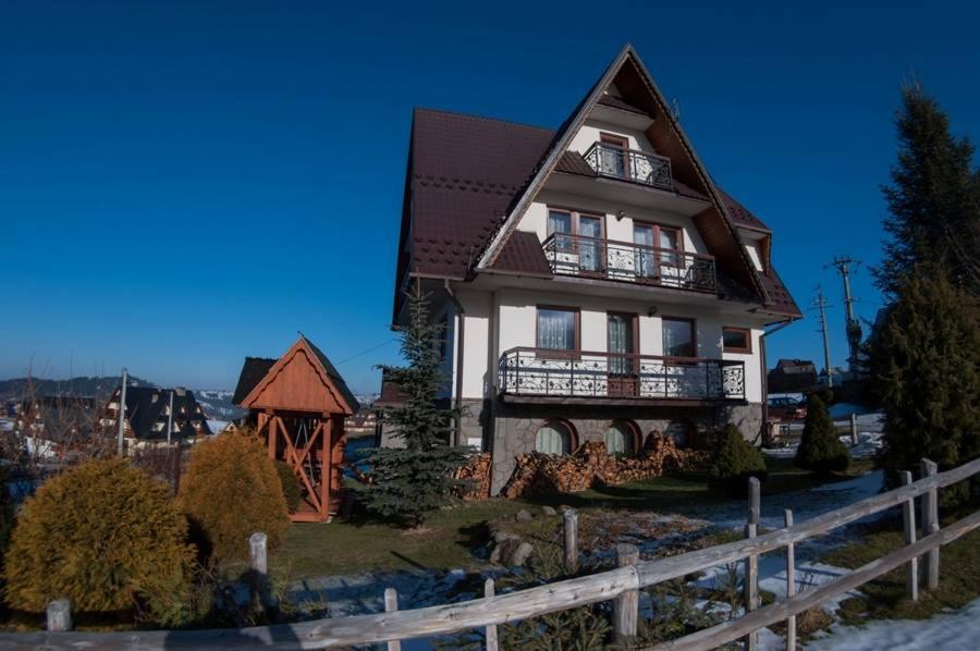 una casa su una collina con una recinzione di Pokoje BUDZOWA 2B a Murzasichle