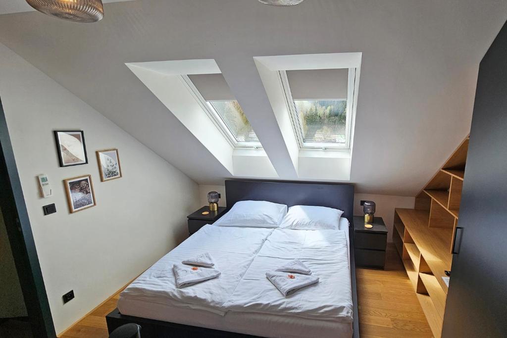 Postel nebo postele na pokoji v ubytování ENJOYHARRACHOV - Atraktivní slunný klimatizovaný apartmán 14 v centru Harrachova se saunou, parkováním, Wifi-WLAN, SAT, herní konzolí, PC s win 10, Netflix zdarma a možností dobíjení auta s jedinečným výhledem na Čertovu horu se skokanskými můstky