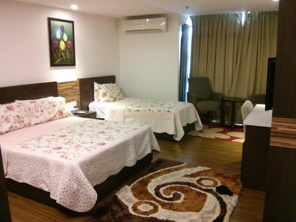 a bedroom with two beds and a living room at Adha Studio & Suite Kota Bharu in Kota Bharu