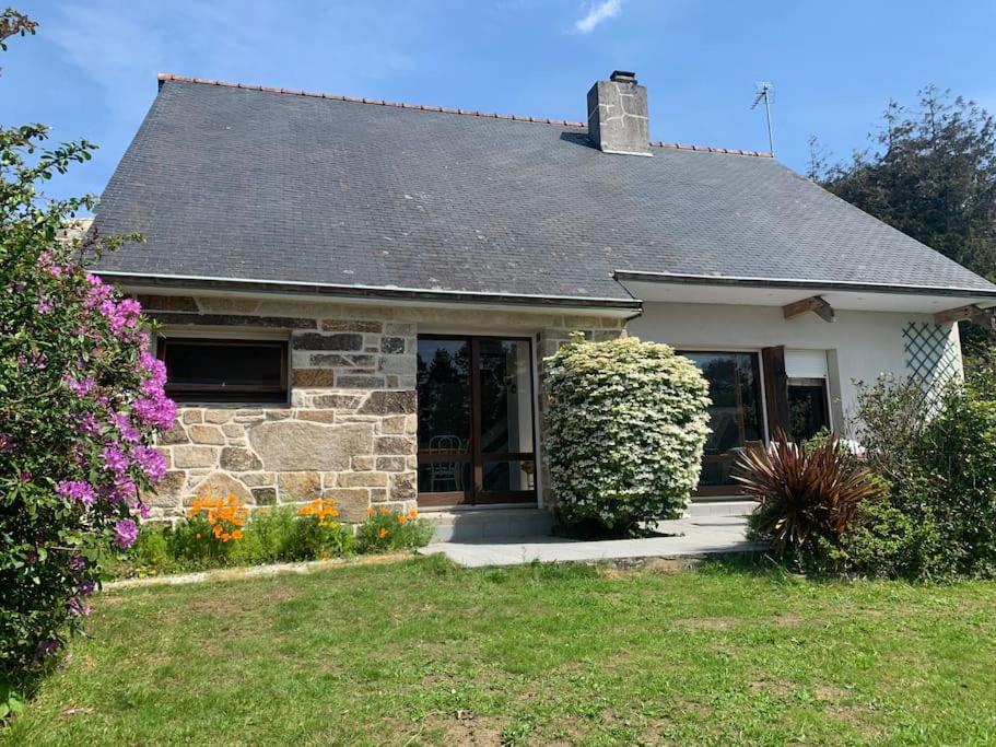 une petite maison blanche avec une cour fleurie dans l'établissement FileOVent, à Combrit