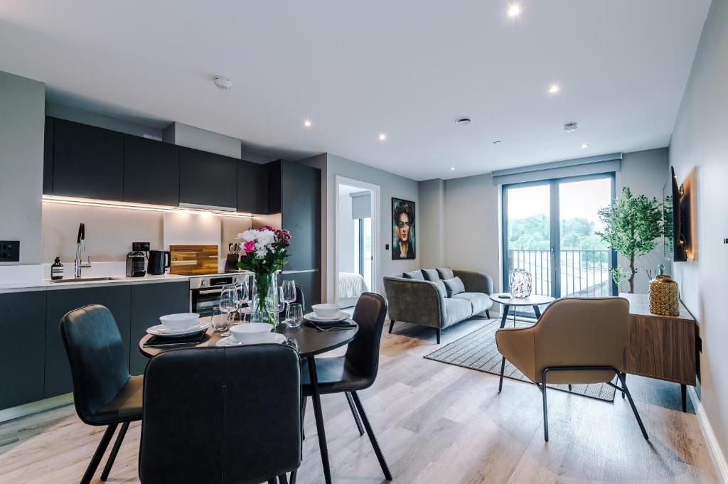a kitchen and living room with a table and chairs at Stylish Leeds City Centre Flat - Free Parking in Leeds